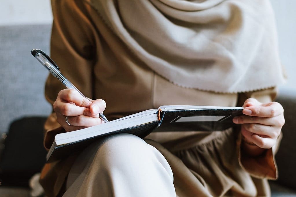 a woman with veil writing in her diary