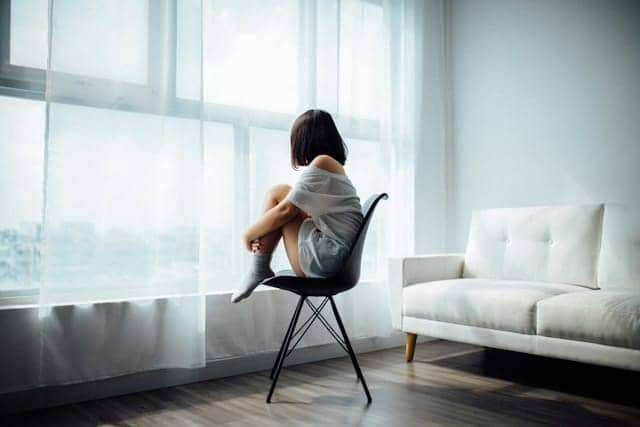 girl looking on the window and sad