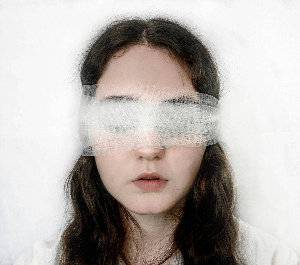 Close-up of a blindfolded woman with a serene expression, exploring themes of introspection.